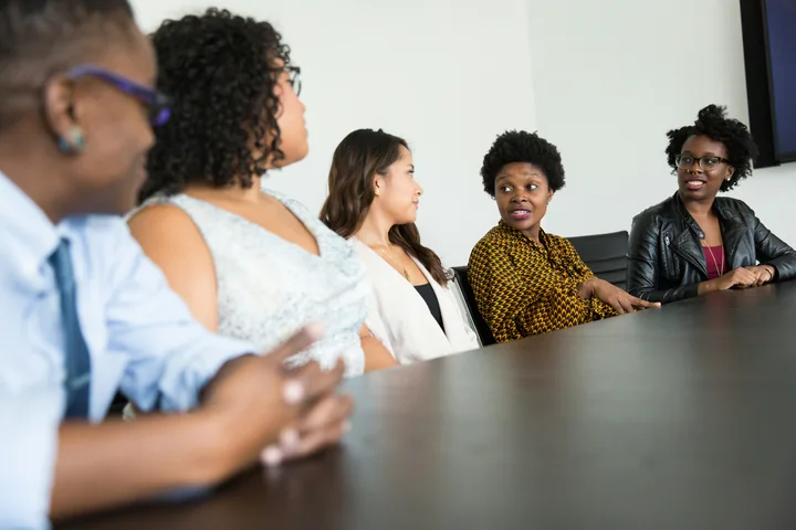 A group of women in conversation around a table