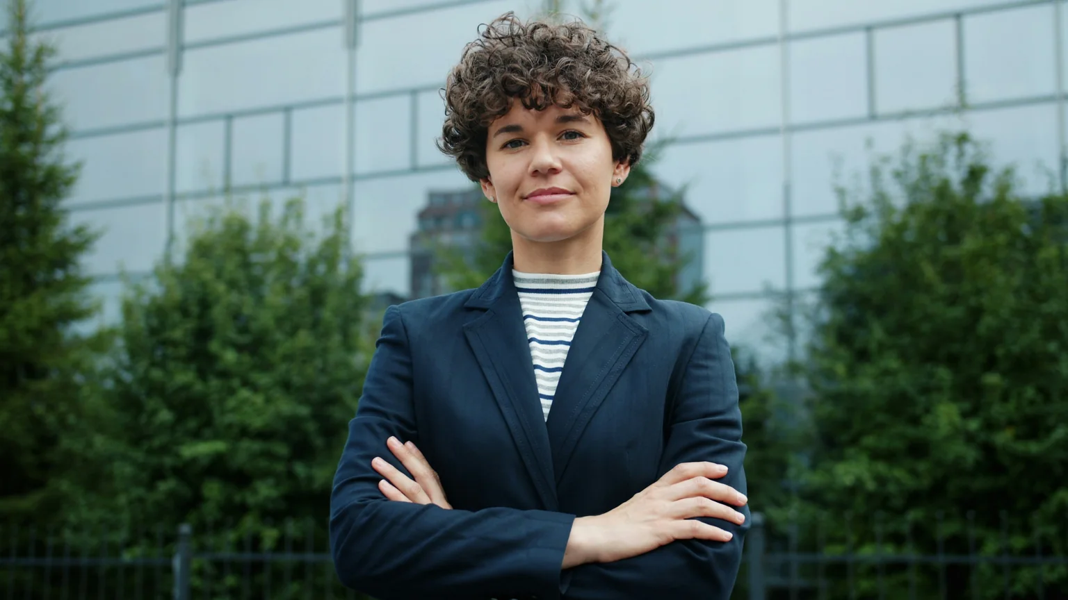 A woman gesturing and smiling while working at a laptop