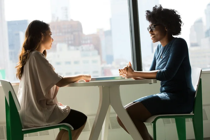 Two women sitting across a table in easy conversation